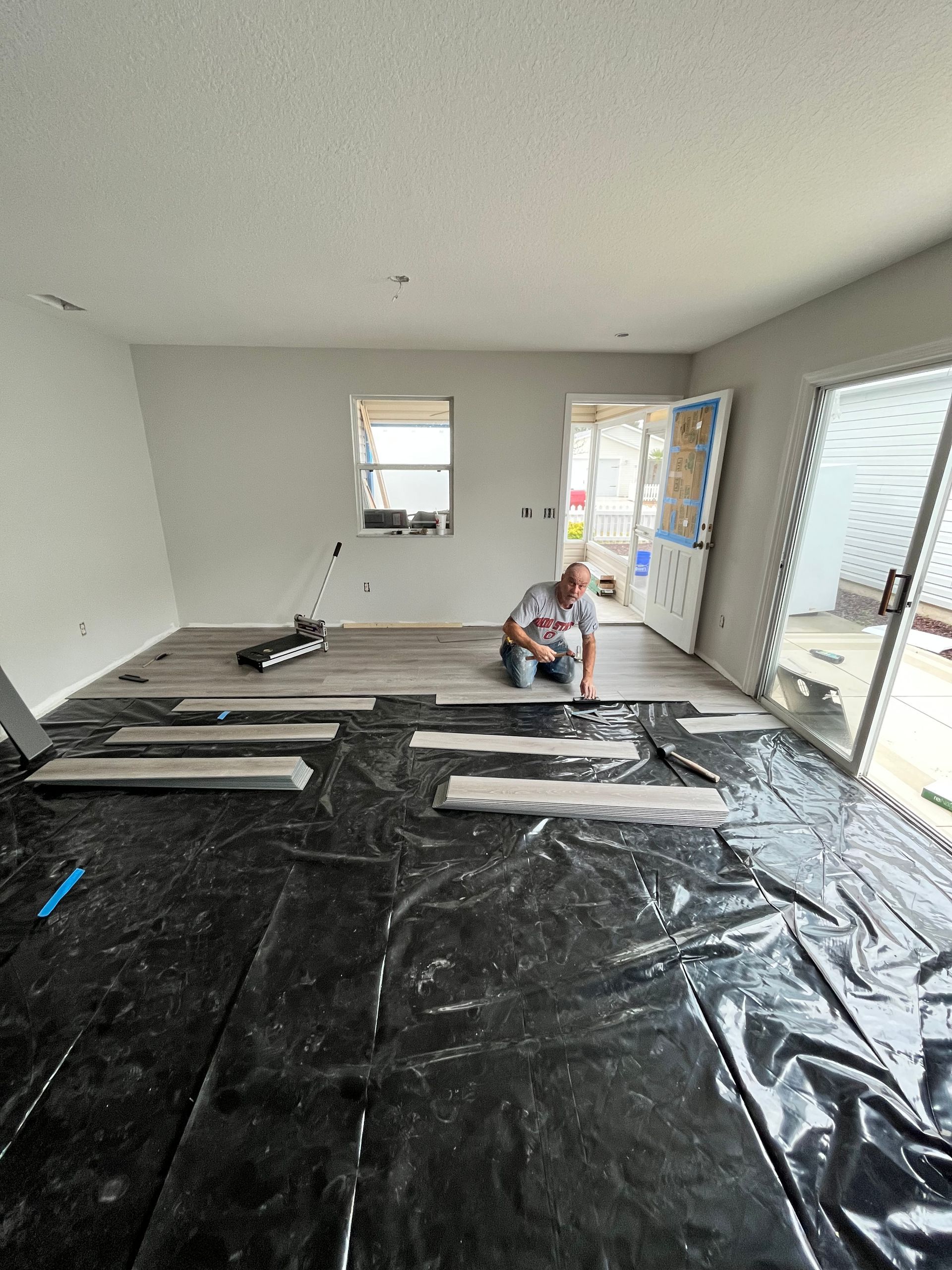 A man is kneeling on the floor in a living room.
