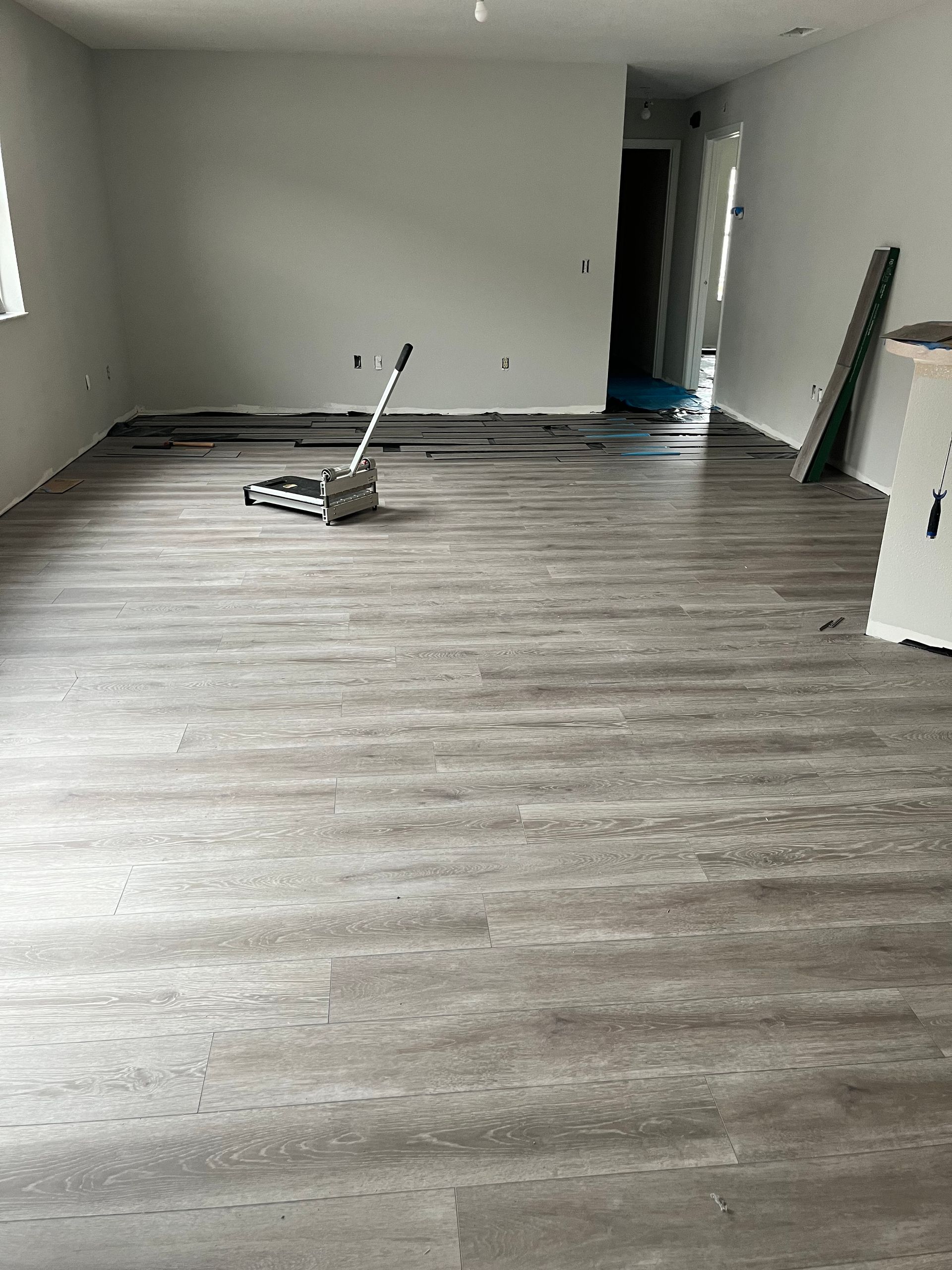A room with a wooden floor and a broom in it.