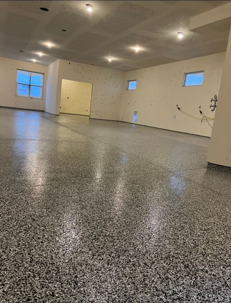 Finished garage with speckled gray floor, white walls, and recessed lighting.
