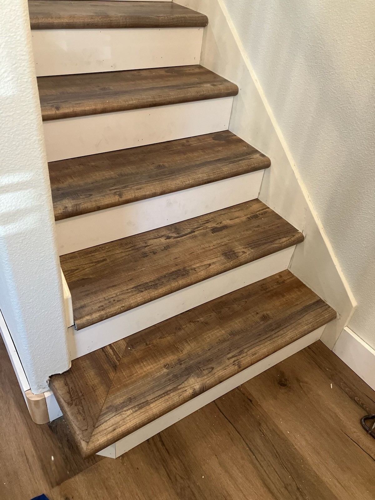 Wooden stair steps with white risers, indoors.