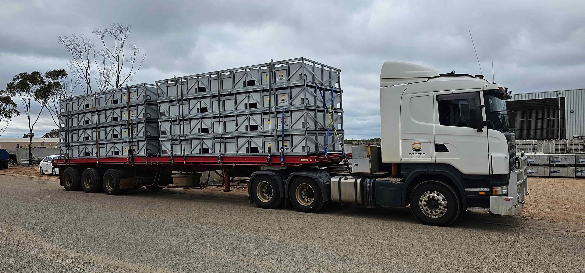 A green water tank is sitting in the middle of a grassy field. — Loogistics in Coolum Beach, QLD