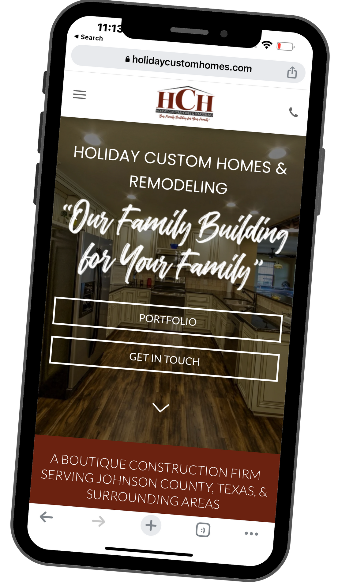 A cell phone is displaying a website for holiday custom homes and remodeling.