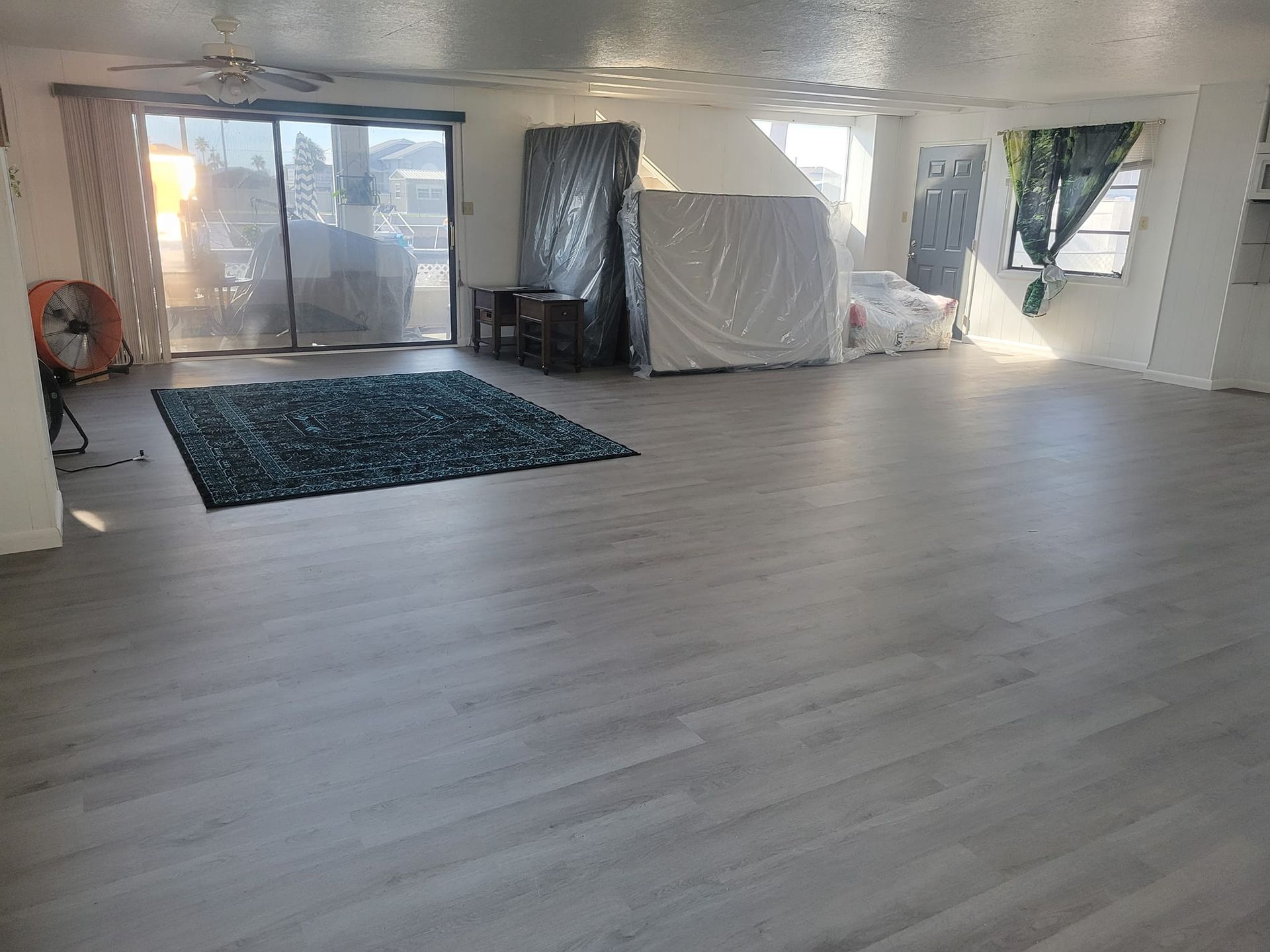 A large room with hardwood floors and a rug.