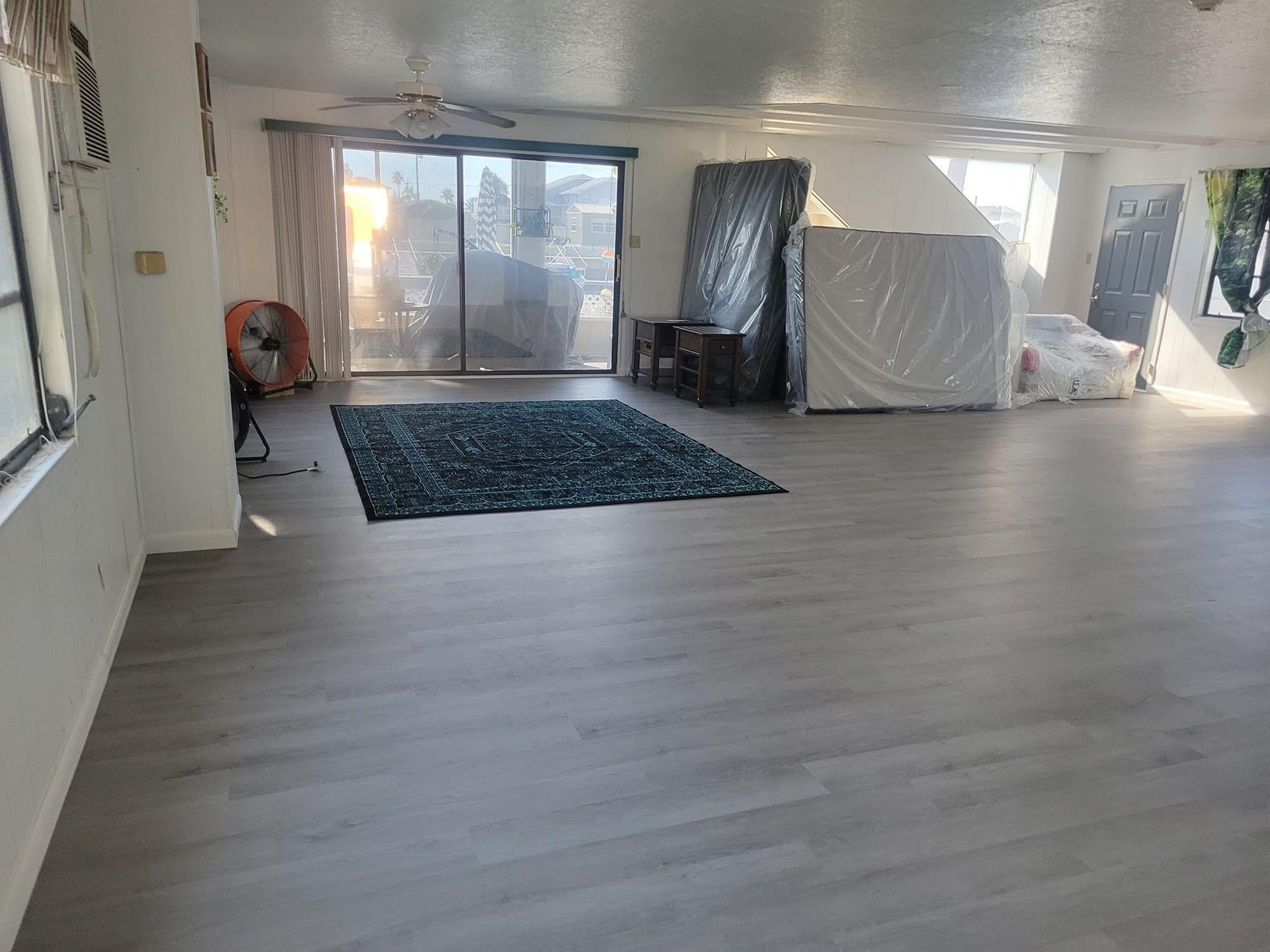 A large living room with hardwood floors and a rug.