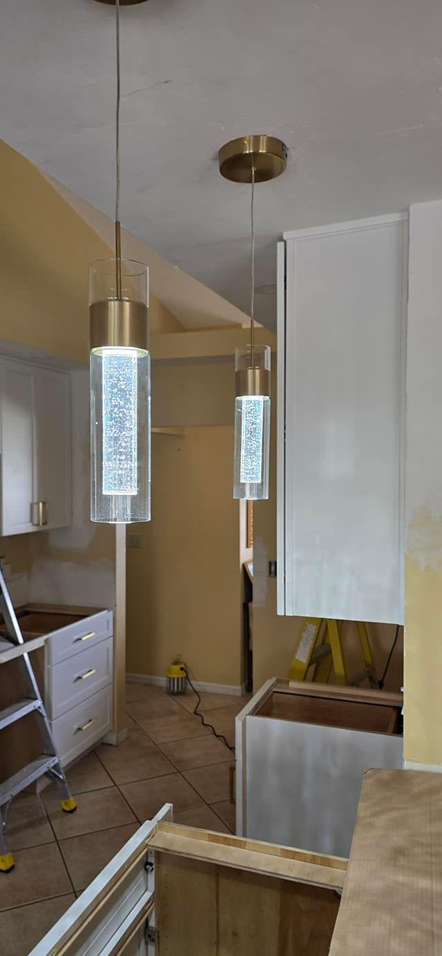 A kitchen under construction with two pendant lights hanging from the ceiling.