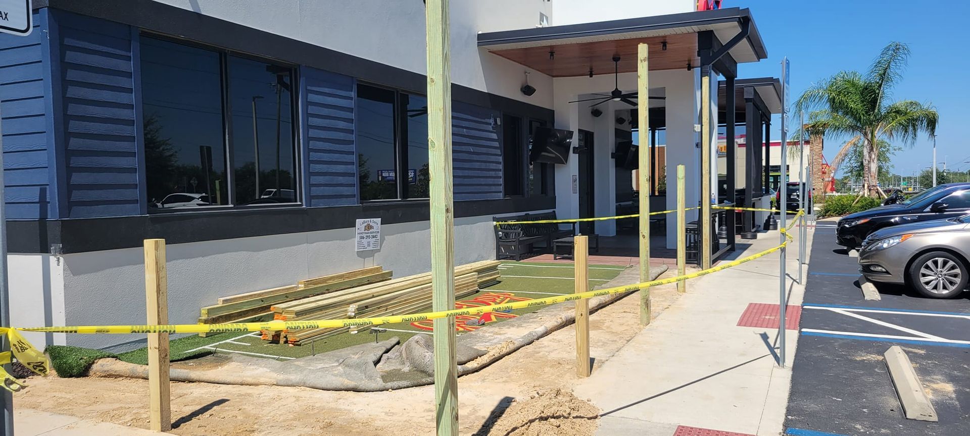 A wooden fence is being built in front of a building.