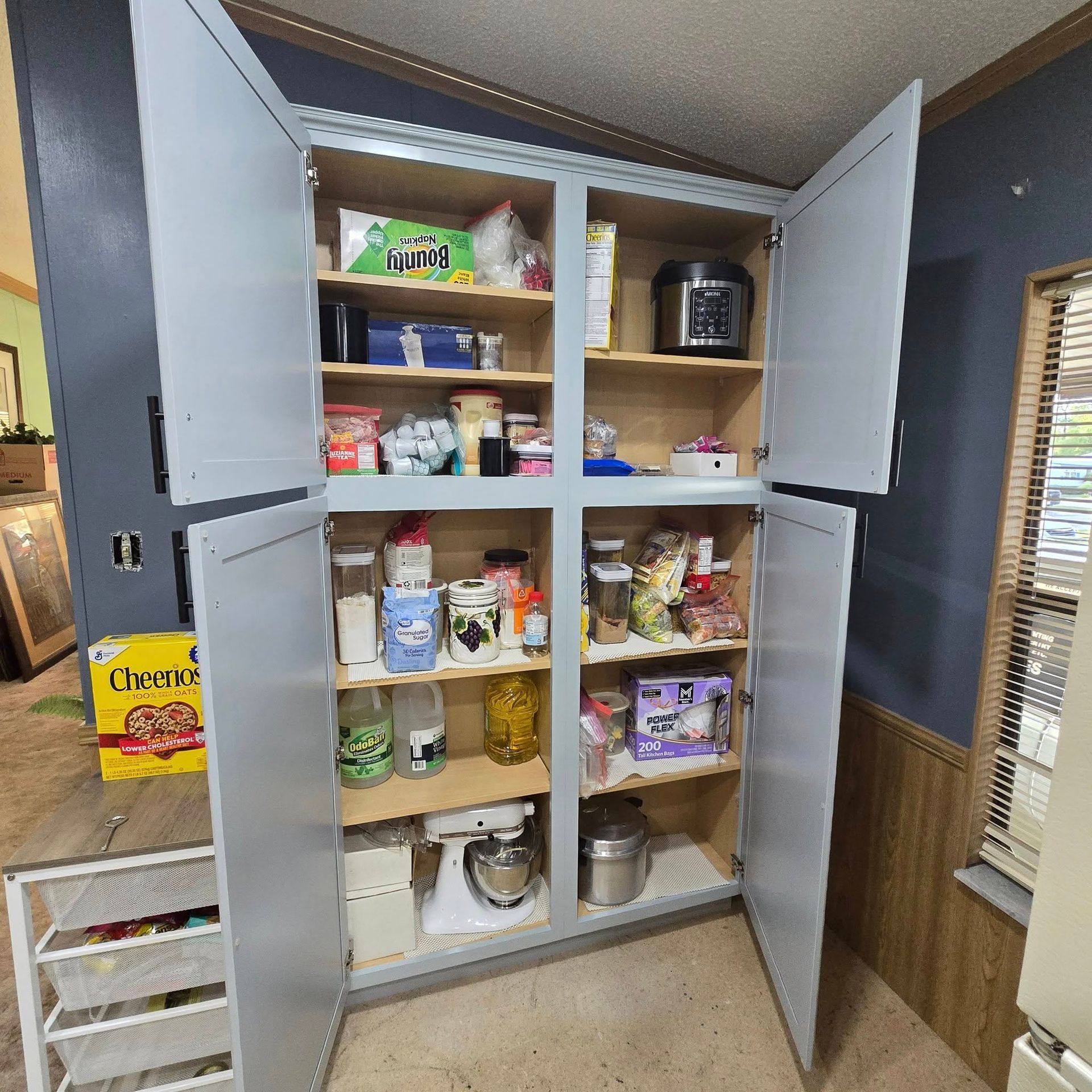 A pantry with the doors open and lots of food in it