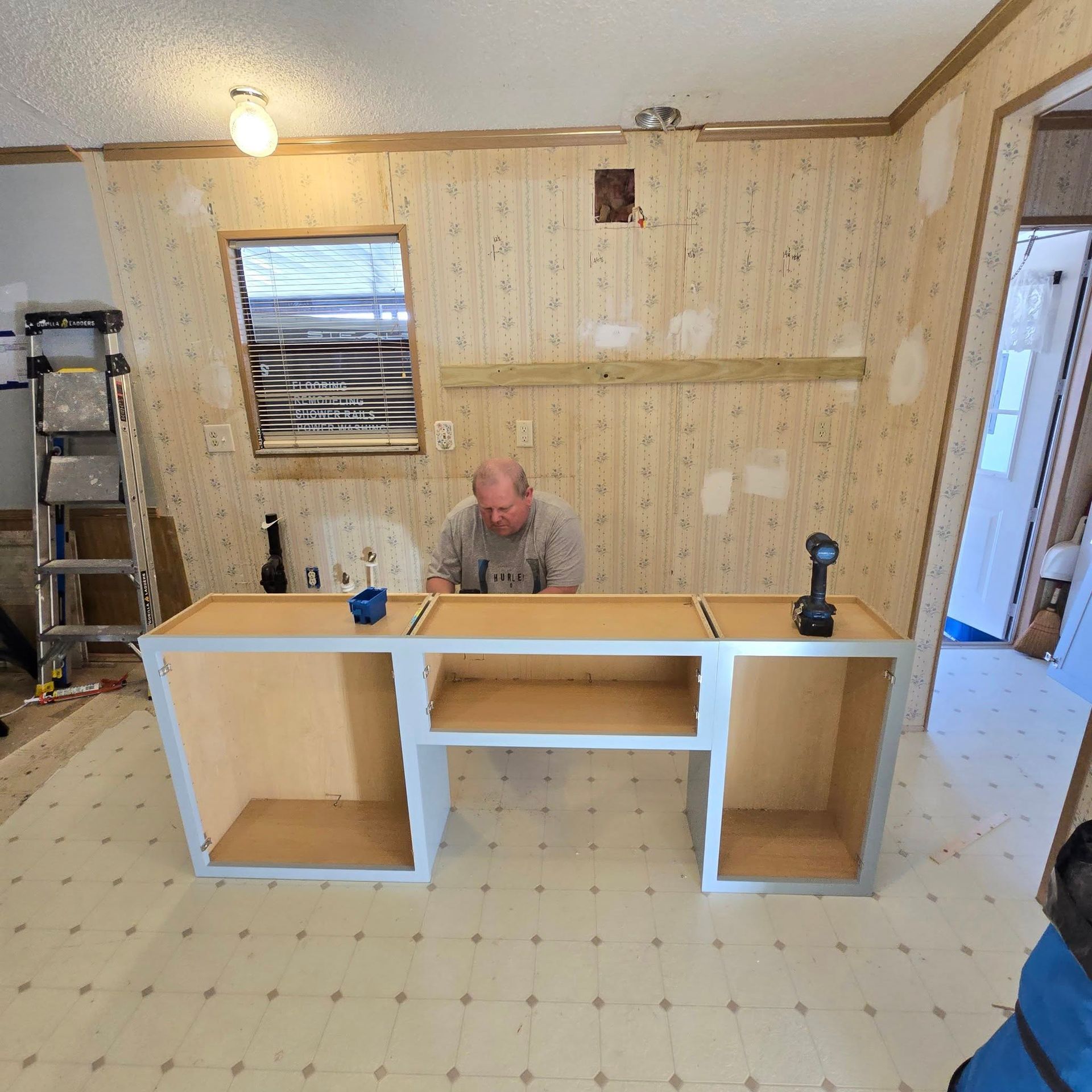 A man is working on a wooden desk in a room