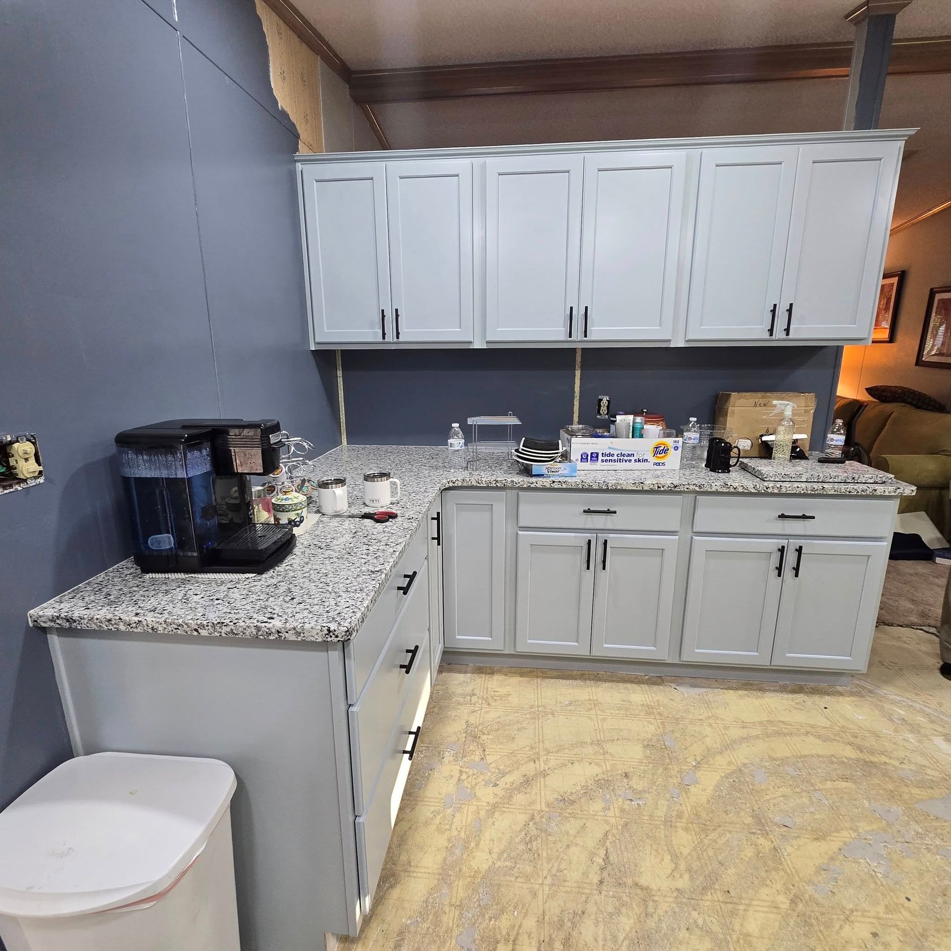 A kitchen with white cabinets and granite counter tops