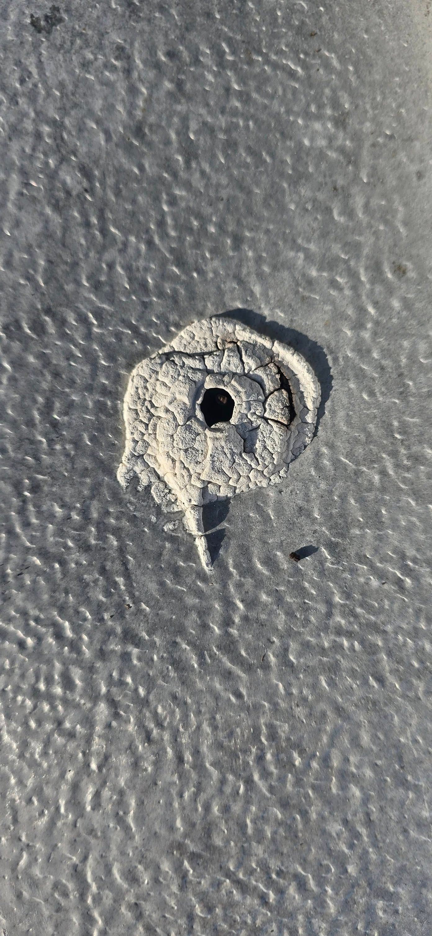 A close up of a hole in the sand on a beach.