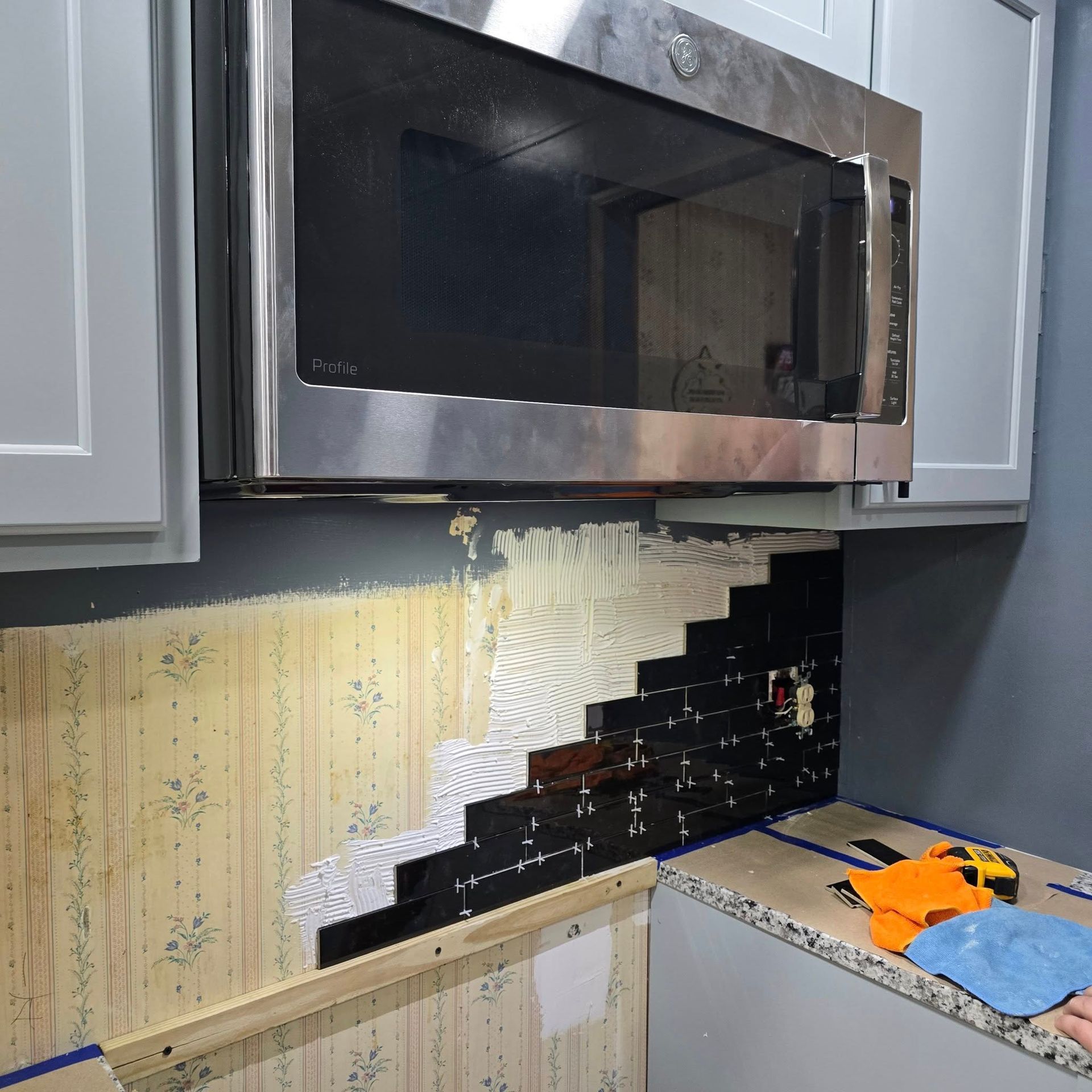 A kitchen with a stainless steel microwave above the counter