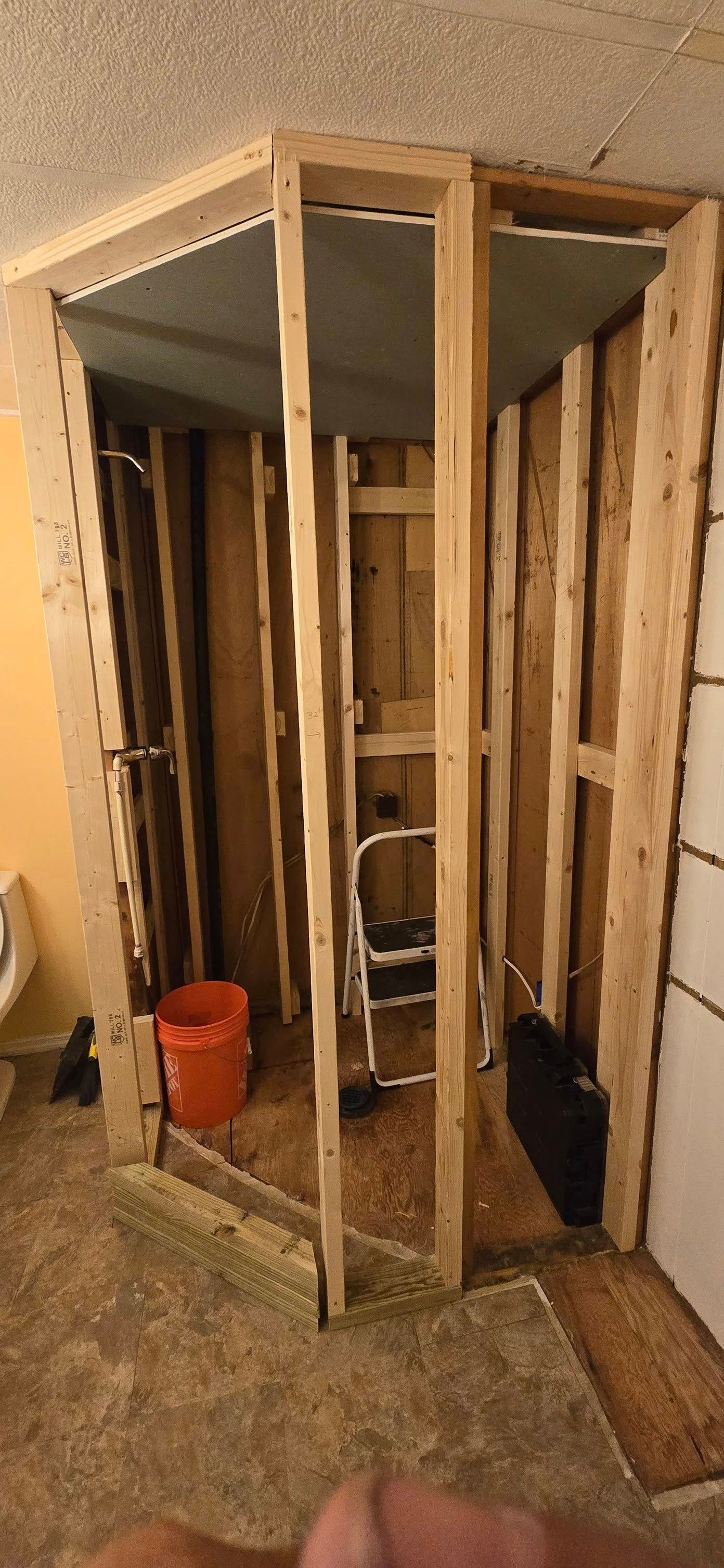 A bathroom is being remodeled with wooden walls and a ladder.