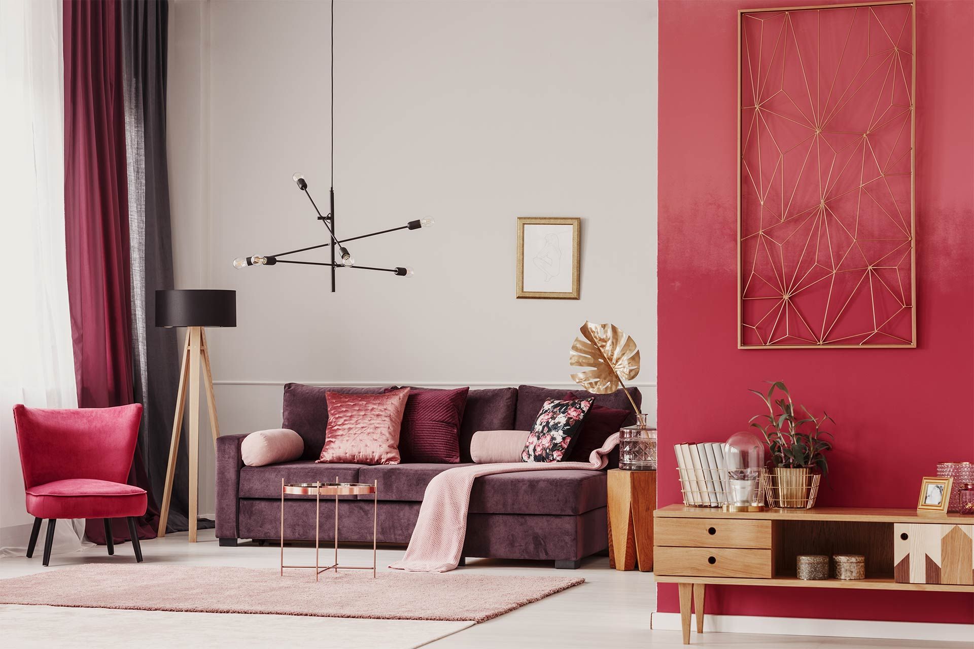 A living room with a couch , chair , table and a red wall.