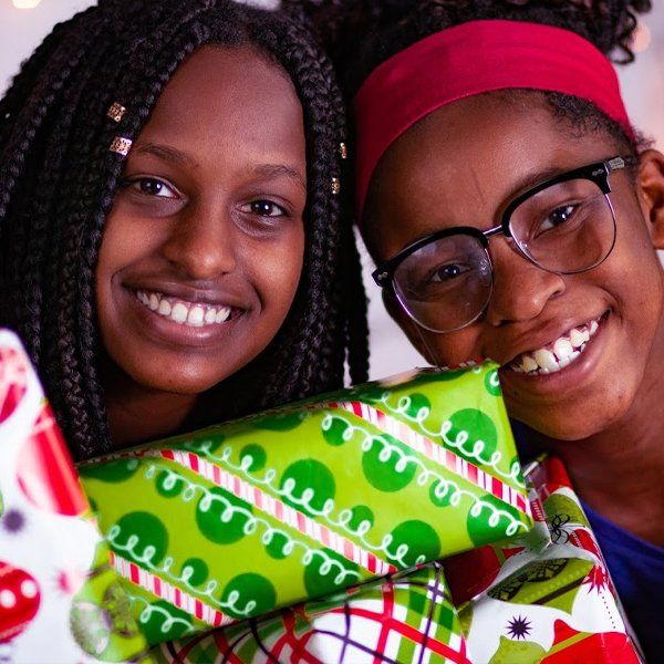 Two teens holding Christmas presents