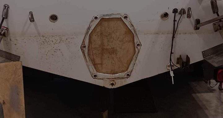 Poupe d'un bateau blanc avec une pièce de bois octogonale et des accessoires fixés.