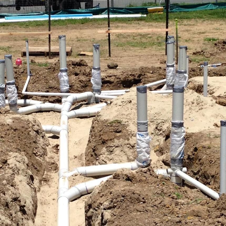 A Bunch Of Pipes Are Laying In The Dirt  — LJG Plumbing In Sarina, QLD
