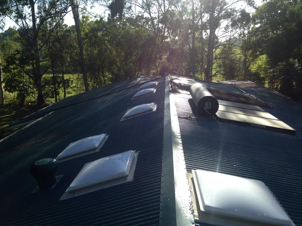 A roof with a lot of skylights and trees in the background — LJG Plumbing In Sarina, QLD