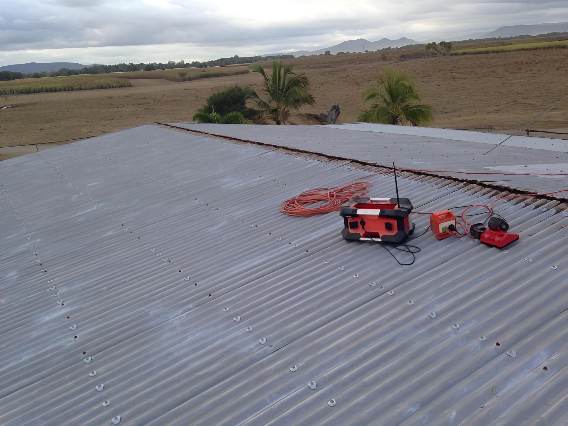 A Carport With A Green Roof Is Sitting In The Middle Of A Lush Green Yard — LJG Plumbing In Sarina, QLD