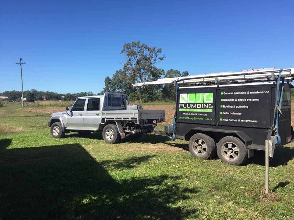 A Gray Pickup Truck Towing a Plumbing Trailer on a Grassy Field — LJG Plumbing In Sarina, QLD