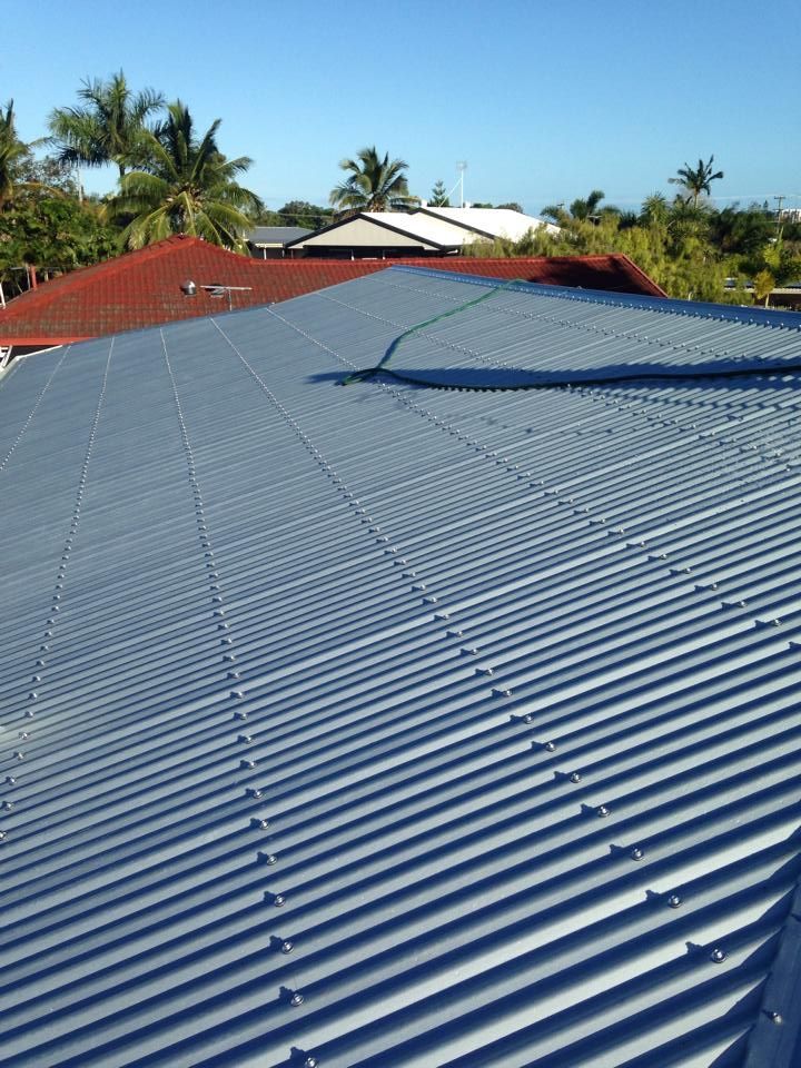 Gray Corrugated Metal Roof With a Red-tiled Roof Section — LJG Plumbing In Sarina, QLD