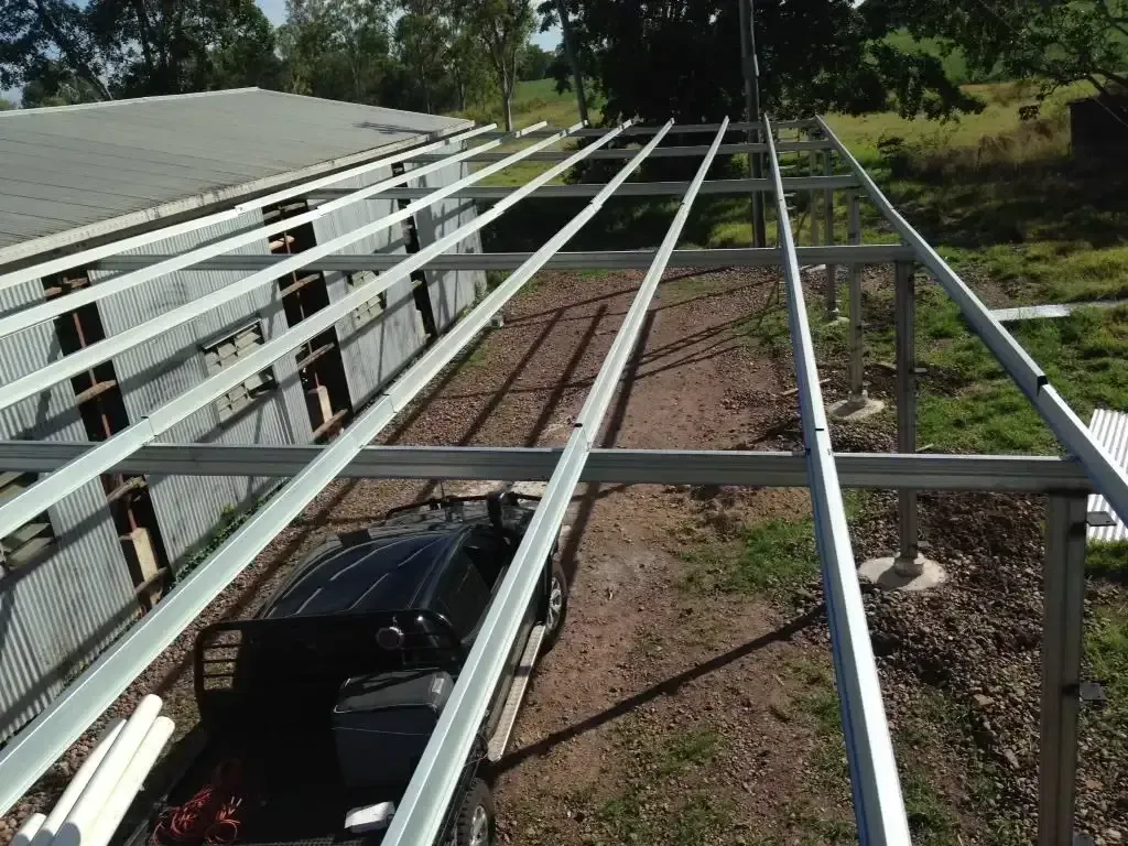 A Man In A Red Hat Is Working On A Wooden Structure — LJG Plumbing In Sarina, QLD