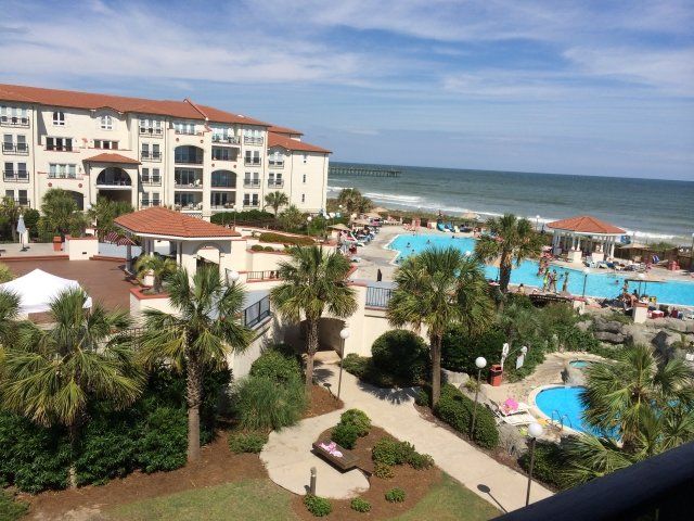 An aerial view of a resort with palm trees and a large pool