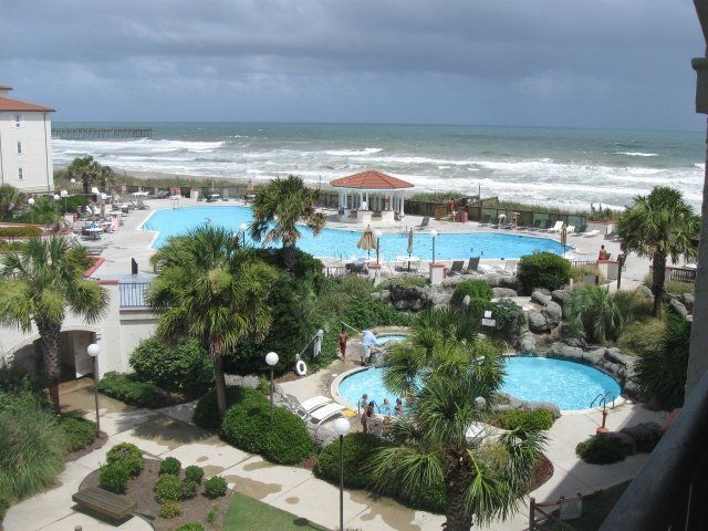 An aerial view of a resort with swimming pools and palm trees