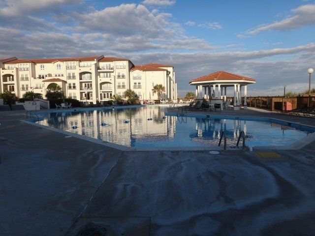 A large building with a swimming pool in front of it