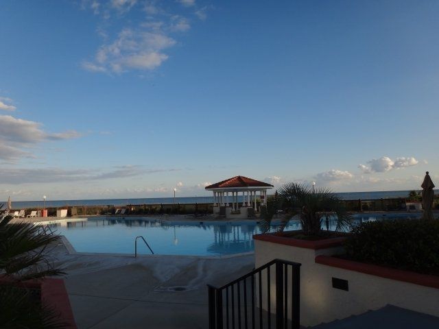A large swimming pool with a gazebo in the background