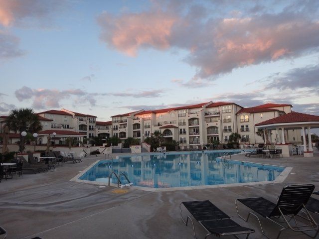 A large building with a swimming pool in front of it