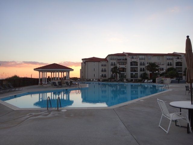 A large swimming pool with a gazebo in the background