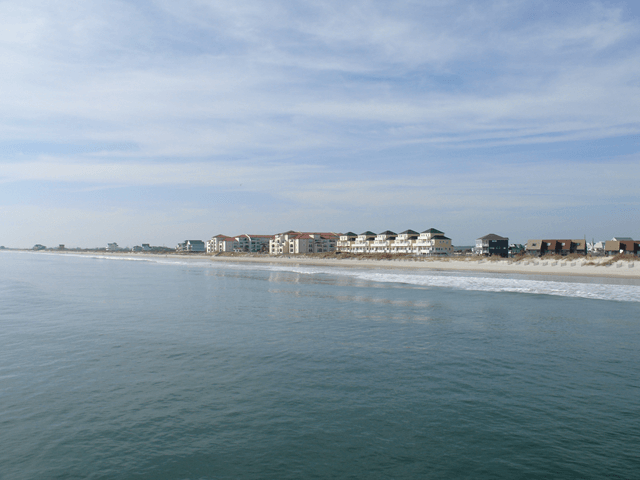 A large body of water with a beach in the background