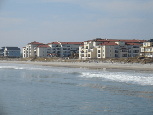 A row of buildings on a beach next to the ocean