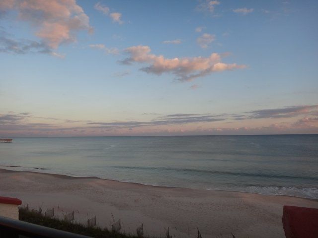 A view of the ocean from a balcony at sunset
