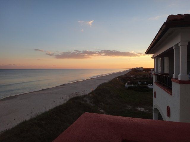 A view of the ocean from a balcony at sunset