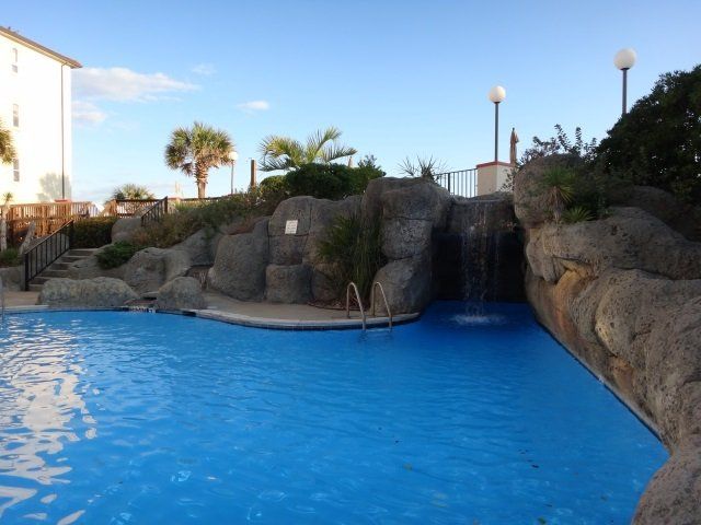 A large swimming pool with a waterfall in the background