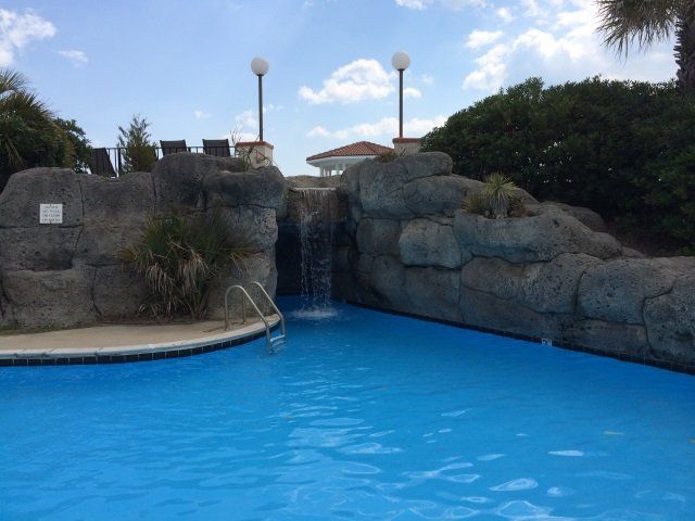 A large swimming pool with a waterfall in the background