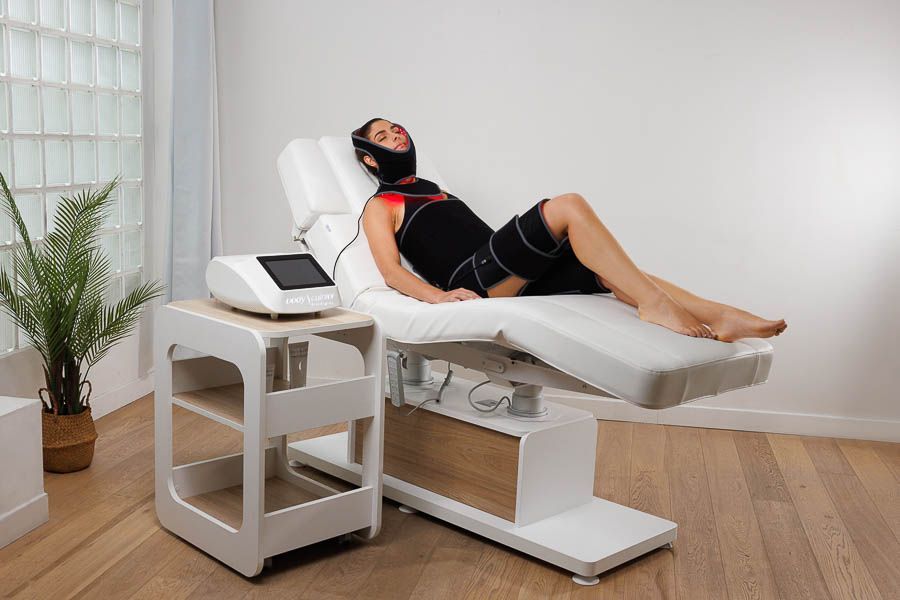 Eine Frau liegt in einem Zimmer auf einem Massagetisch.