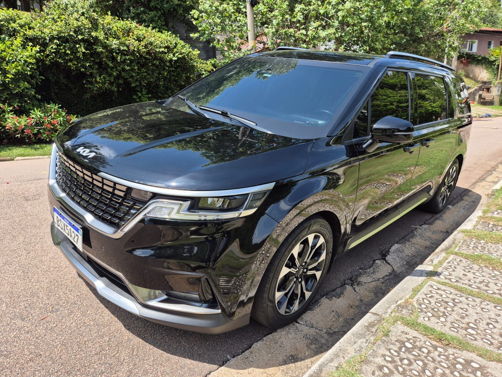Um carro preto está estacionado na beira da estrada.