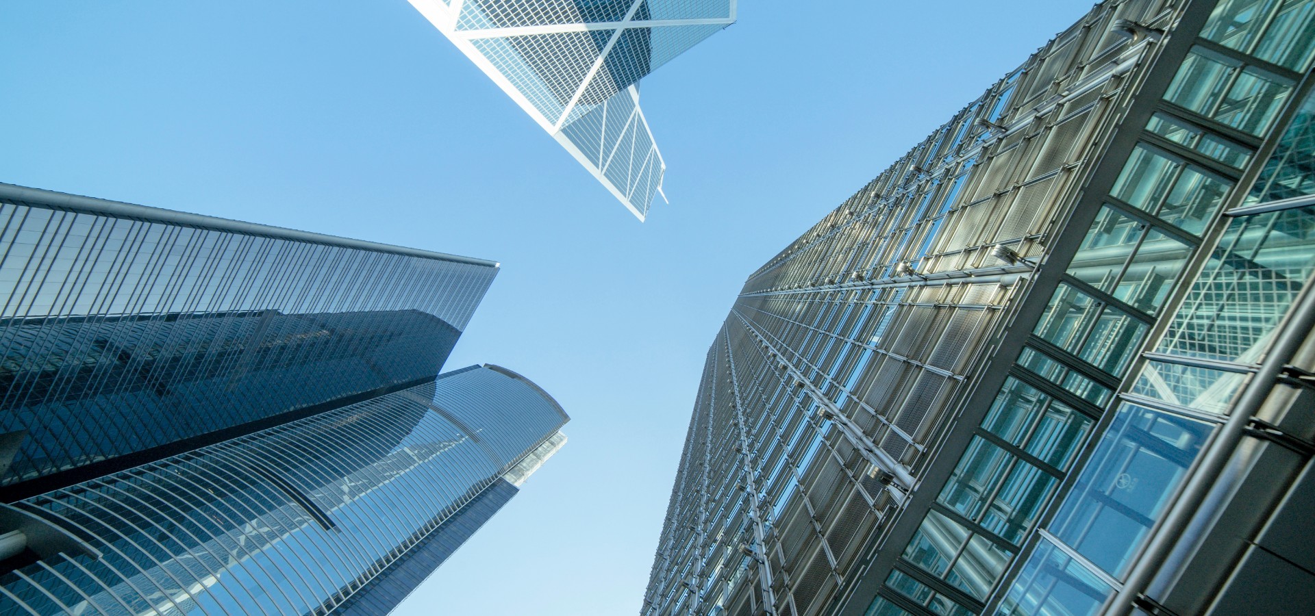 Upward view of modern glass skyscrapers against a blue sky