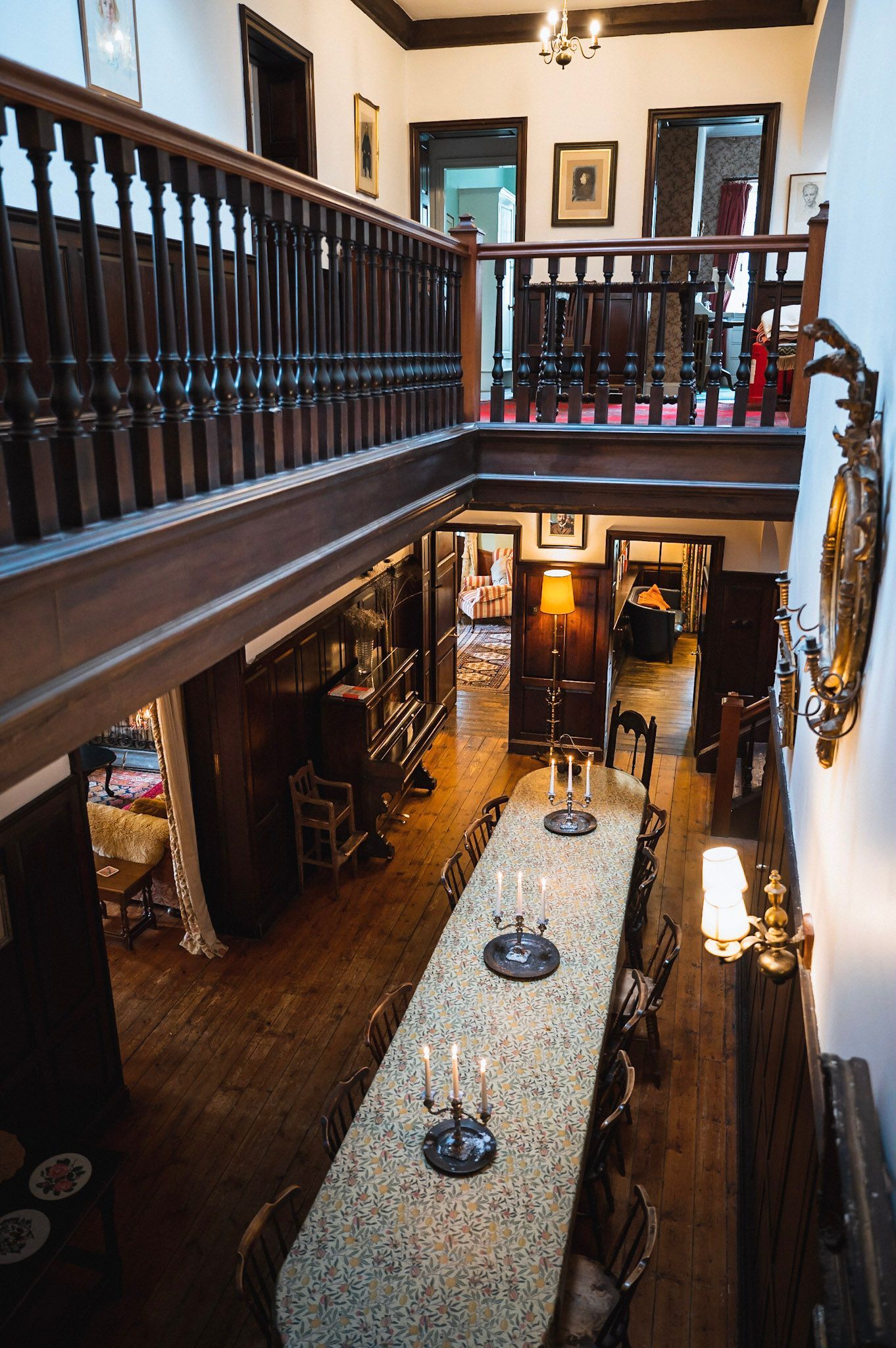 People dining outdoors around a wooden table, with one person holding a bowl of shrimp and grits in the foreground.