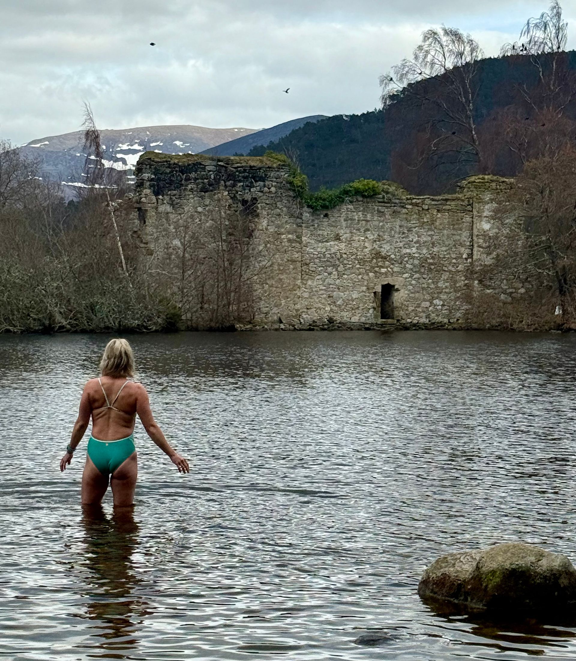 A lady walking into the loch in scotland