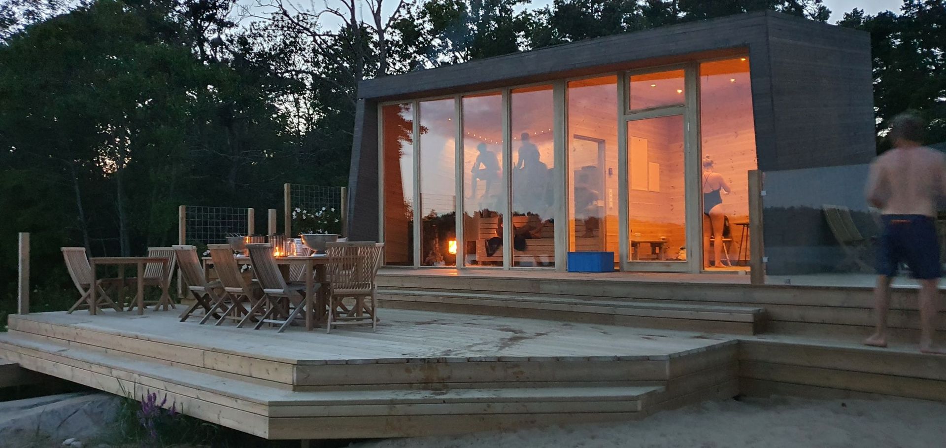 Boat in turquoise water near a sandy islet, with mountains in the background under a clear sky.