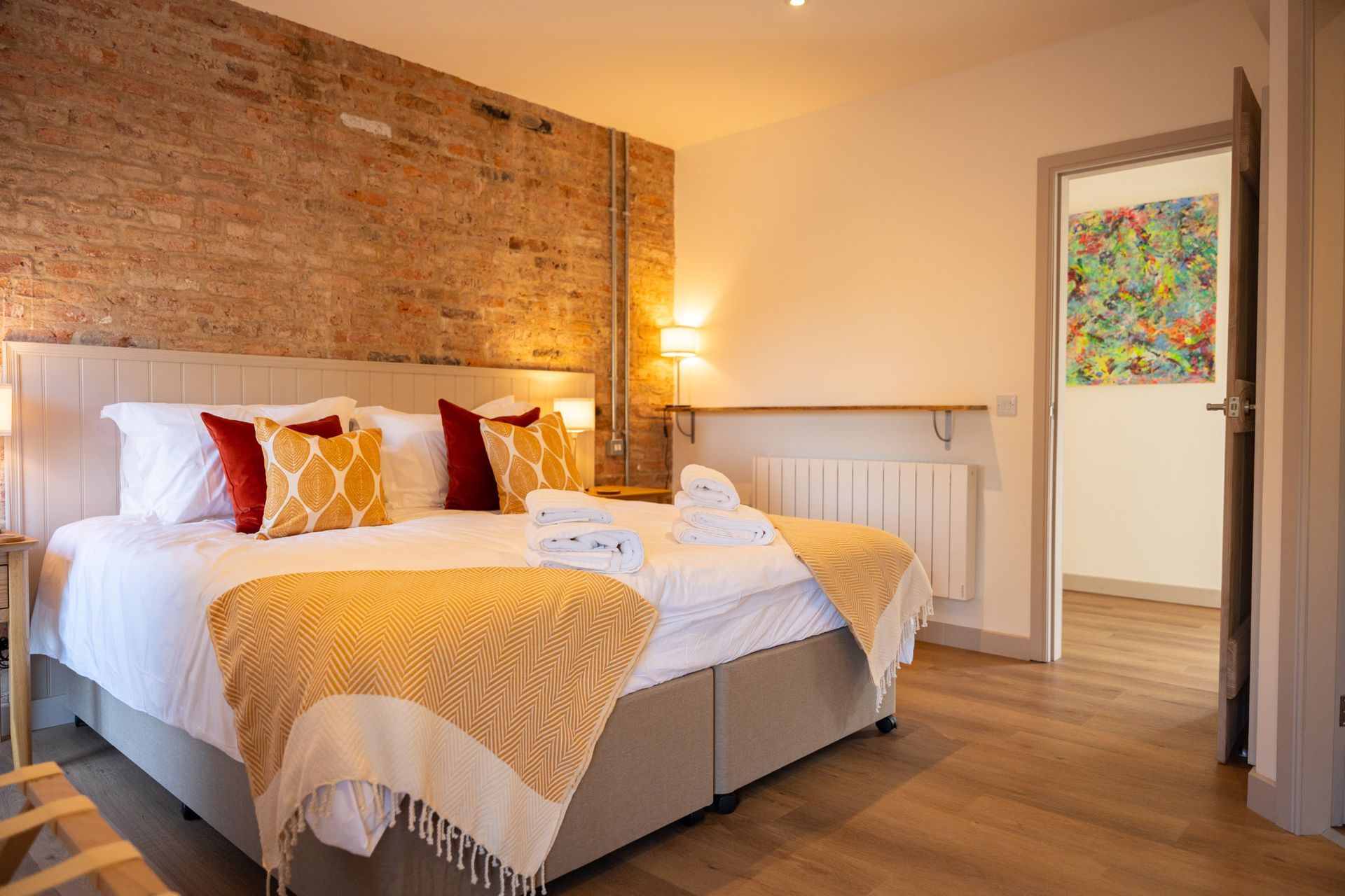 bedroom with king bed and yellow cushions and lamps