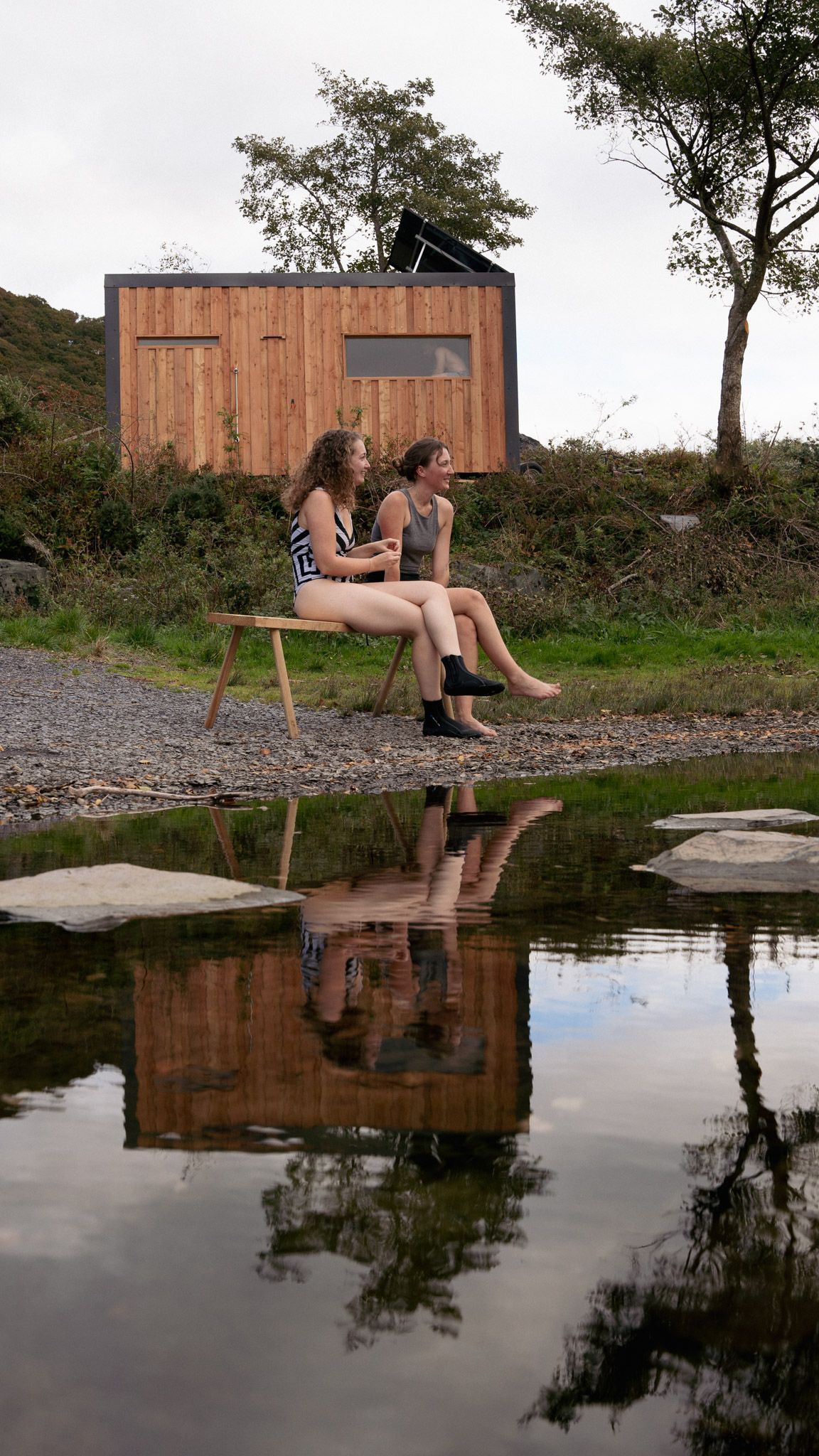Two women sitting outside a sauna