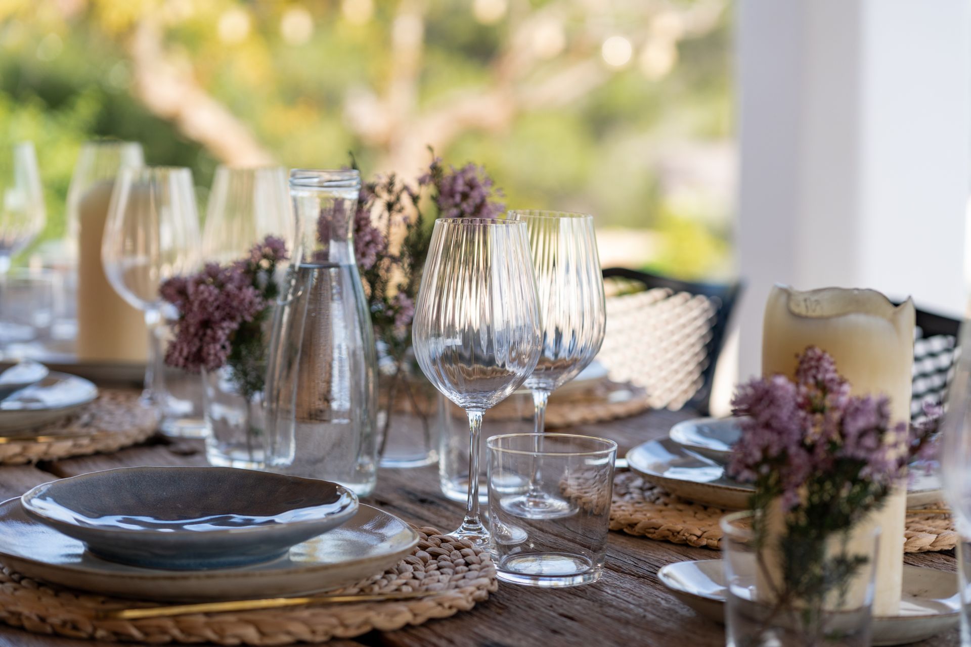 A dining table set up with glasses and plates