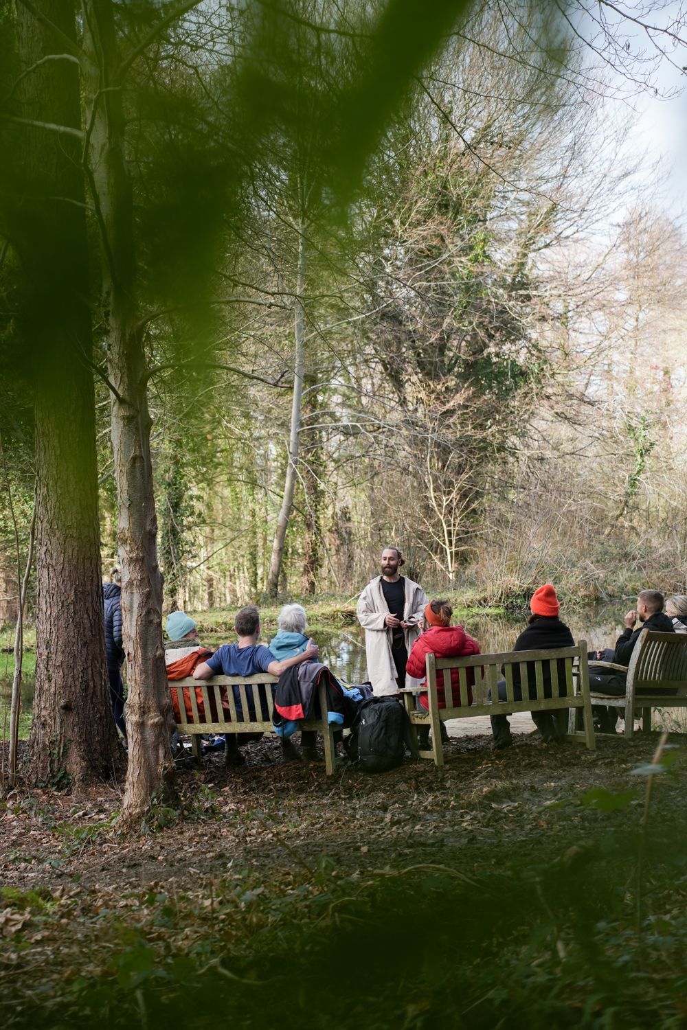 people sitting on benches in a woodland