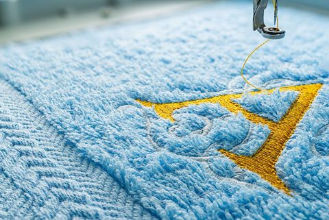 A Close Up Of A Sewing Machine Embroidery On A Blue Towel — Coastal Monogramming In Maroochydore, QLD