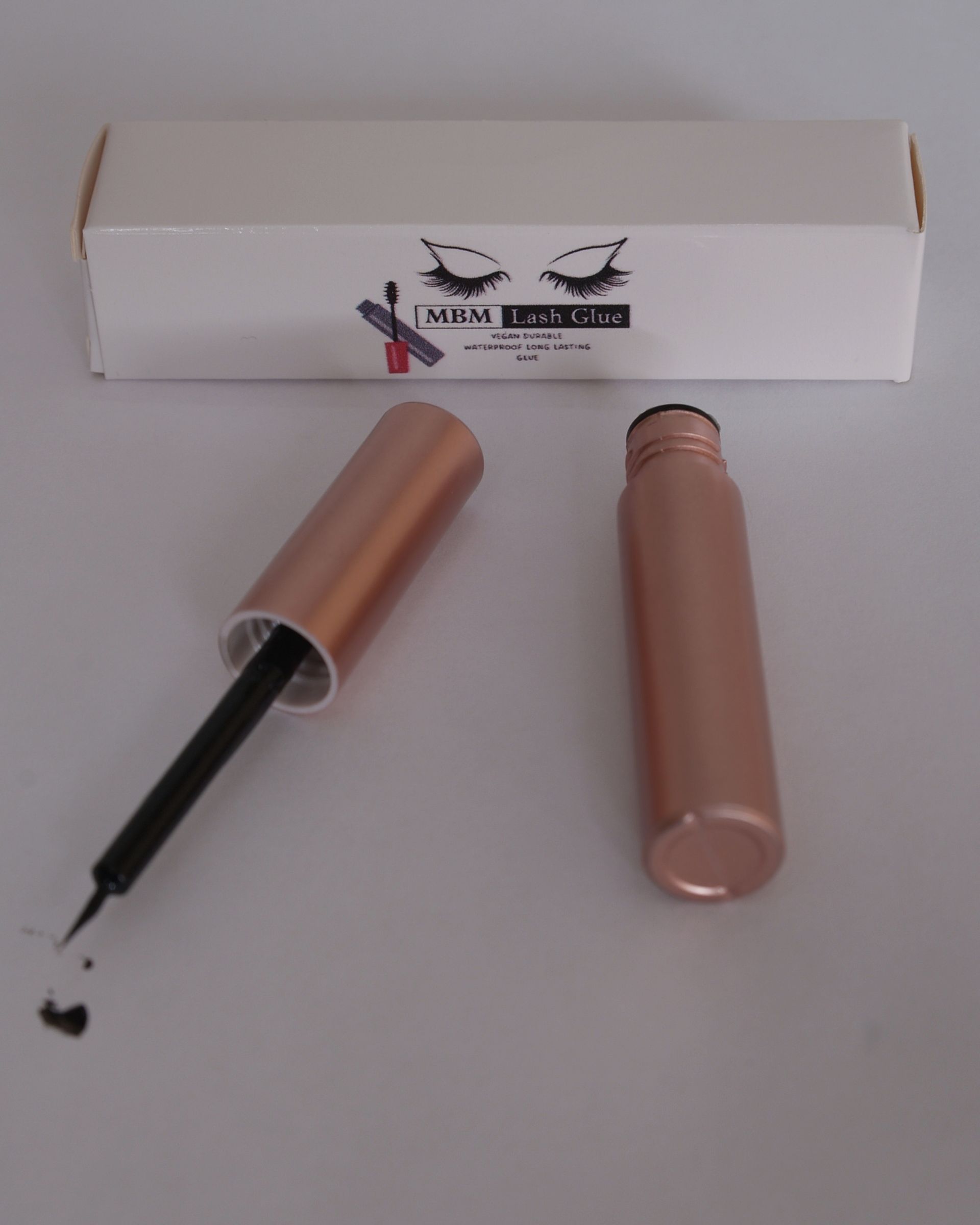 A bottle of eyeliner sits next to a box