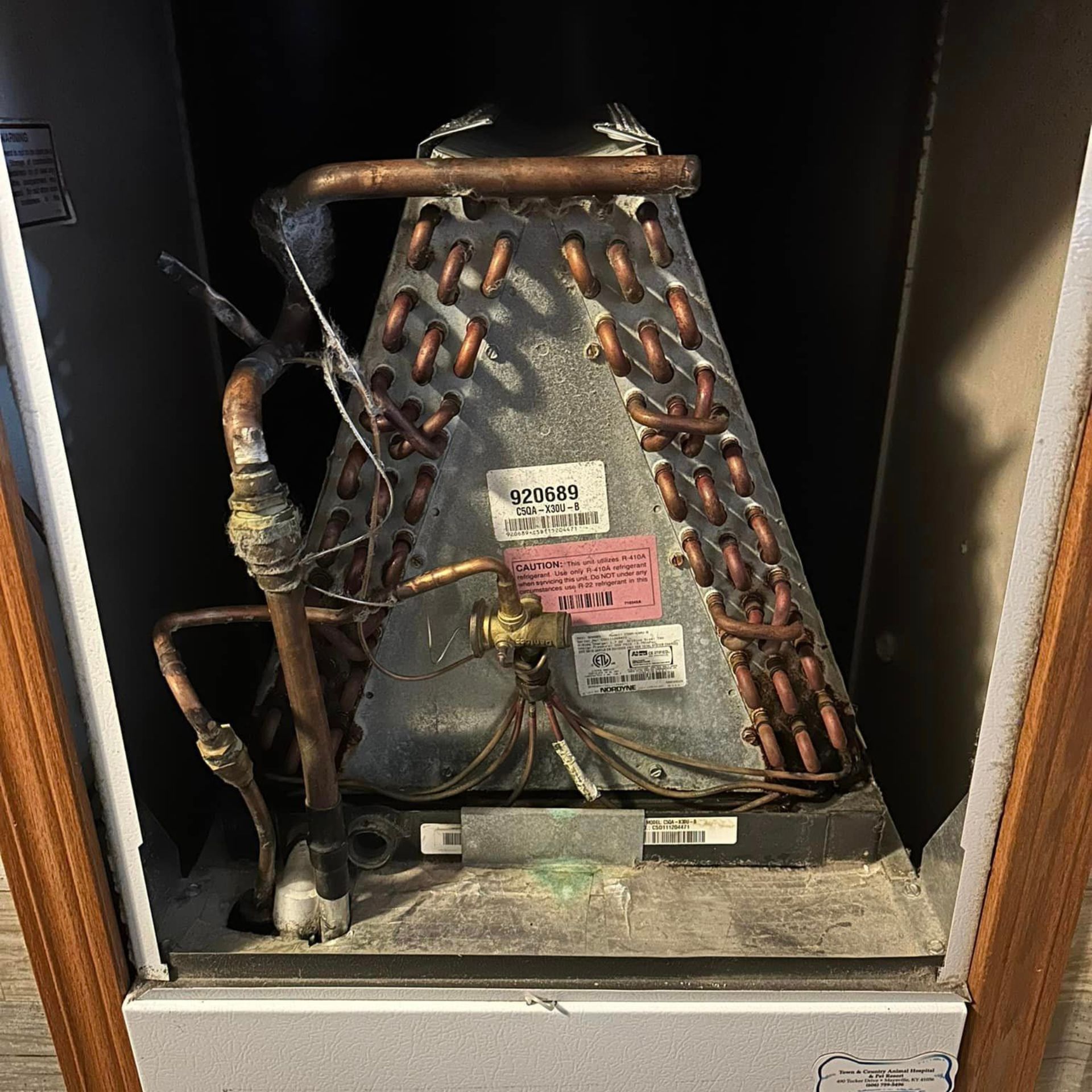 A dirty air conditioner coil is sitting inside of a box.